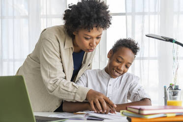 Mutter hilft Sohn bei den Hausaufgaben zu Hause - VPIF07622