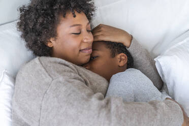 Son sleeping in mother's arms at home - VPIF07676