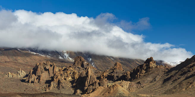 Spanien, Kanarische Inseln, Felsformationen im Nationalpark El Teide mit dem in Wolken gehüllten Berg Teide im Hintergrund - WGF01430