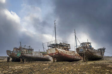 Rainbow and beached old wooden fishing boats on shore at Salen