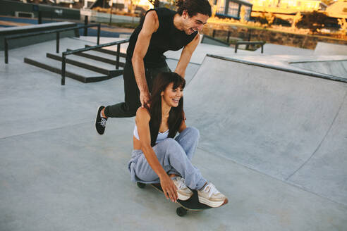 Junger Mann und Frau haben Spaß mit dem Skateboard im Skatepark. Paar skatet im Skatepark. - JLPSF19438