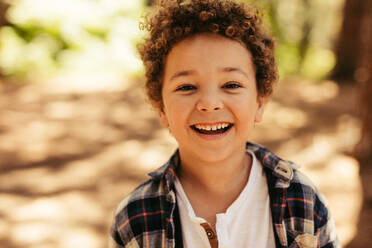 Close up portrait of cute boy smiling outdoors. Kid looking at camera and laughing. - JLPSF19538