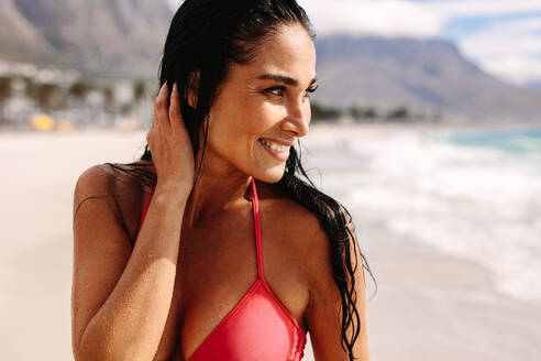 Junges weibliches Bikinimodell, das am Meer spazieren geht. Schöne junge Frau, die den Sommerurlaub am Strand genießt. - JLPSF19636