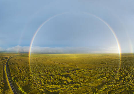 Luftaufnahme eines vollen Regenbogens über grüner Landschaft mit Ringstraße, Südisland. - AAEF16380