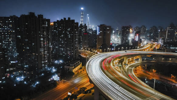 Luftaufnahme eines Wohnviertels in der Nähe einer Autobahn in Shanghai bei Nacht. - AAEF16434