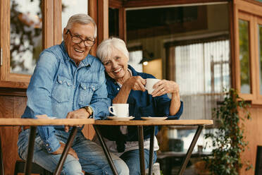 Verliebtes älteres Paar im Café. Schönes Porträt eines alten Mannes und einer alten Frau, die am Kaffeetisch sitzen und in die Kamera schauen. - JLPSF19972