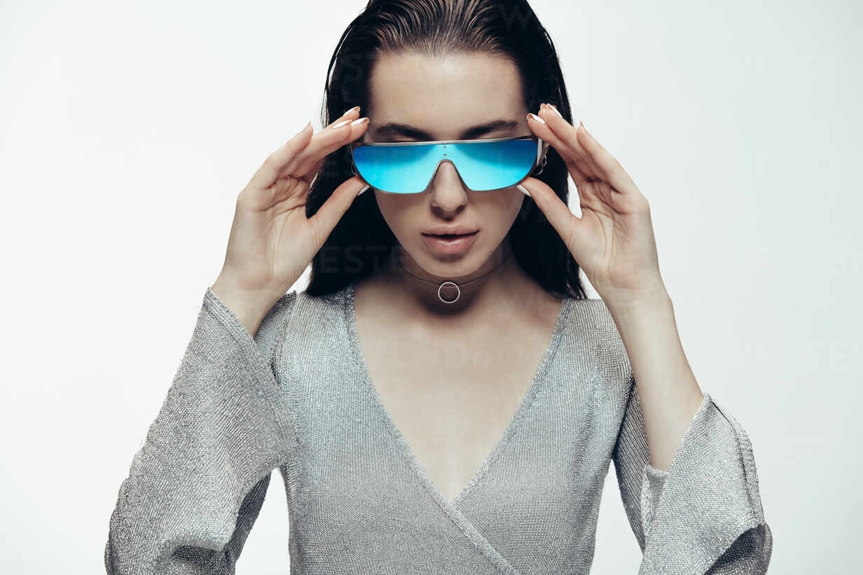 https://us.images.westend61.de/0001748789pw/funky-fashion-portrait-of-female-model-wearing-silver-outfit-and-blue-mirrored-sunglasses-futuristic-female-model-posing-in-studio-JLPSF20222.jpg