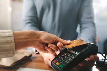 Pharmacist accepting credit card by contactless payment. Woman purchasing products in the pharmacy. Pharmacist hands charging with credit card reader. - JLPSF20262