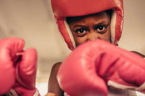 Junge in Boxerausrüstung während eines Boxkampfes. Nahaufnahme eines entschlossenen boxenden Jungen. - JLPSF20346