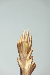 Weibliche Hände in Goldfarbe auf grauem Hintergrund. Hände der Frau mit goldener Farbe gemalt. - JLPSF20428