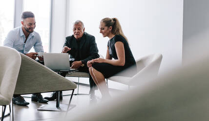 Group of business people meeting in office foyer. Business team discussing over new project in meeting. - JLPSF21119