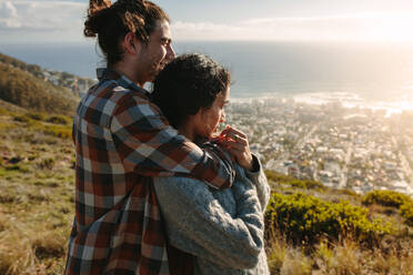 Romantic man embracing his girlfriend from behind and looking at view. Couple in love admiring the view. - JLPSF21202