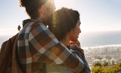 Close up portrait of young man hugging his girlfriend on a sunny day. Couple looking at view from mountain. - JLPSF21204