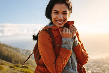 Porträt einer schönen jungen Frau in warmer Kleidung, die an einem Wintertag im Freien steht und fröstelt. Weibliche Wanderung an einem kalten Wintertag. - JLPSF21220