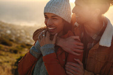 Close up portrait of handsome young man hugging his woman and smiling.  Beautiful couple outdoors together