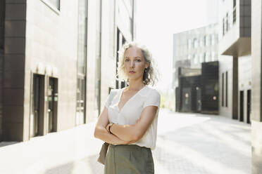 Confident businesswoman standing with arms crossed on sunny day - SEAF01500