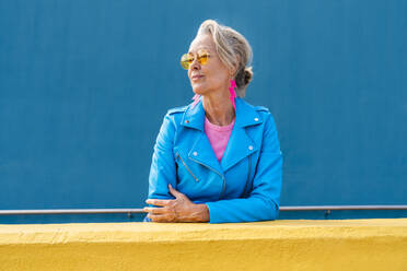 Fashionable mature woman in front of blue wall - OIPF02634