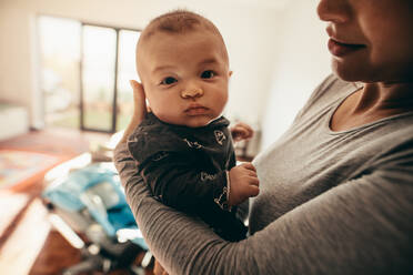 Nahaufnahme einer Mutter mit ihrem Kleinkind. Ausschnitt einer Mutter mit ihrem Baby, die zu Hause steht. - JLPSF21652