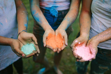 Frauen stehen im Freien mit Holi-Farben in den Händen. Frauen stehen mit drei verschiedenen Holi-Farben in den Händen. - JLPSF22004