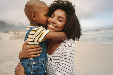 Sohn küsst seine Mutter am Meer. Junge genießt den Tag mit seiner Mutter am Strand. - JLPSF22314