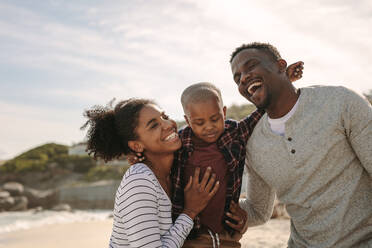 Lächelnder junger Mann und Frau mit ihrem Sohn am Strand. Schöne Familie im Urlaub am Strand. - JLPSF22332