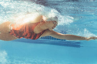 Unterwasseraufnahme einer jungen Frau, die im Schwimmbad schwimmt. Eine Schwimmerin im Schwimmbad. - JLPSF22389
