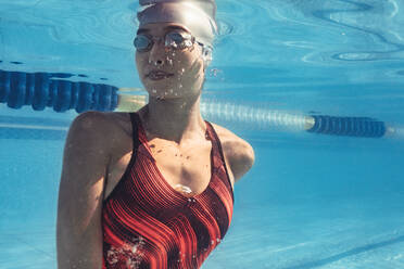 Frau Schwimmerin im Inneren des Pools Drehen beim Schwimmen. Unterwasseraufnahme von professionellen Schwimmer im Inneren des Schwimmbades. - JLPSF22398