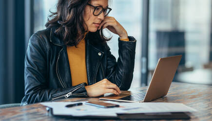 Beschäftigte Frau sitzt am Schreibtisch und arbeitet am Laptop. Asiatische Geschäftsfrau arbeitet am Laptop-Computer im Büro. - JLPSF22694