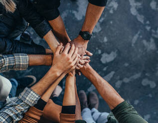 Top view of business people putting their hand together. Business team stacking hands over each other. - JLPSF22789