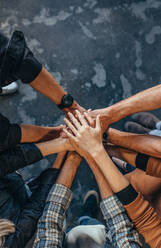 Overhead view of business team putting hands together at the office. Office workers making a stack of hands with copy space. - JLPSF22790