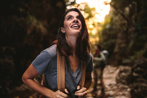 Schöne Frau wandern durch einen Bergpfad mit Freunden in den Rücken. Kaukasische Frau mit Rucksack Wandern in Berg und Blick nach oben lächelnd. - JLPSF22812
