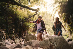 Eine Gruppe von Freunden auf einer Bergwanderung. Männer und Frauen wandern durch Felsen auf einem Bergpfad. - JLPSF22854