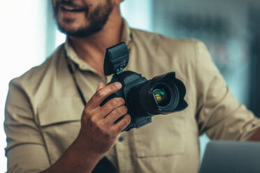 Porträt eines Fotografen, der eine DSLR-Kamera hält. Der Fotograf hält eine Digitalkamera und spricht. - JLPSF23246
