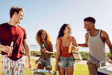 Eine Gruppe multiethnischer Männer und Frauen, die zusammen am Strand Spaß haben. - JLPSF23503