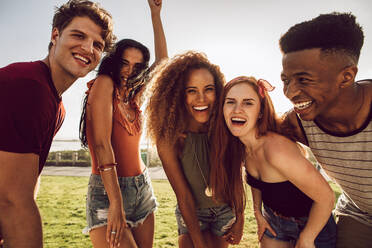 Group of multi-ethnic friends dancing outdoors and laughing. Friends having a great time on their summer vacation. - JLPSF23543