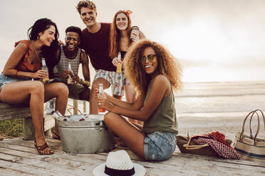 Junge Menschen um Getränk Wanne sitzen am Strand. Schöne Frauen mit Freunden hängen am Strand im Urlaub. - JLPSF23554