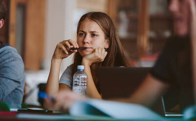 Studentin hört einer Vorlesung in einem College-Klassenzimmer zu. Frau studiert in der Universitätsklasse. - JLPSF23793