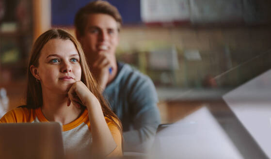 Hübsche Teenager-Studentin, die im Klassenzimmer der Vorlesung Aufmerksamkeit schenkt. Frau, die im Klassenzimmer der Hochschule studiert. - JLPSF23797