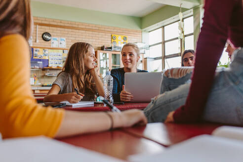 Eine Gruppe junger Leute unterhält sich nach der Vorlesung im Klassenzimmer. Studenten unterhalten sich in der Pause zwischen den Vorlesungen. - JLPSF23798