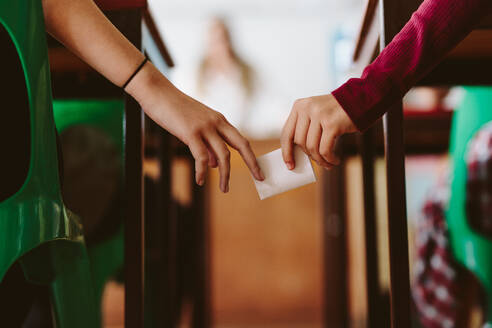 Universitätsstudenten, die während der Prüfung heimlich Testnoten weitergeben. Schummeln während der Prüfung im Klassenzimmer. - JLPSF23834