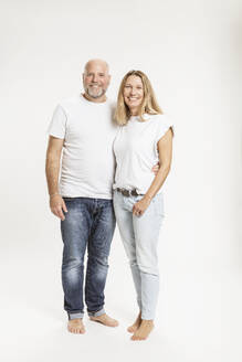 Smiling couple standing together against white background - SDAHF01204