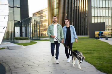 Ehepaar mit Hund auf dem Gehweg - MOEF04327