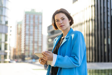 Young businesswoman wearing blue blazer holding tablet PC - MOEF04372