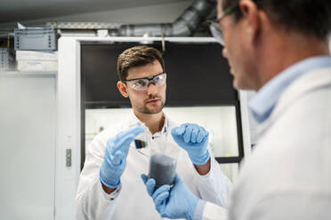 Scientist gesturing and discussing with colleague at laboratory - DIGF19271