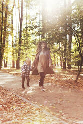 Mutter und Sohn laufen zusammen im Park - ONAF00198