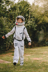 Small boy in an astronaut suit playing outside. Kid pretending to be an astronaut. - JLPSF24138