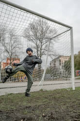 Junge übt Fußball auf einem Sportplatz - ANAF00316