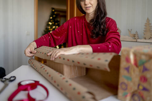 Frau packt Weihnachtsgeschenke zu Hause ein - ANAF00320