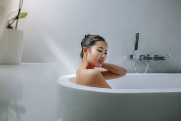 Junge asiatische Frau in der Badewanne. Frau badet in einer Badewanne. - JLPSF24184