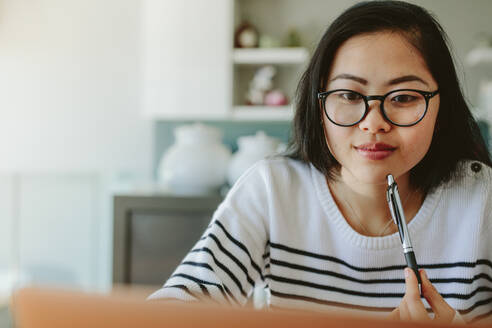 Eine Frau mit Brille schaut auf einen Laptop, eine junge Frau benutzt einen Laptop und hält einen Stift in der Hand. - JLPSF24188